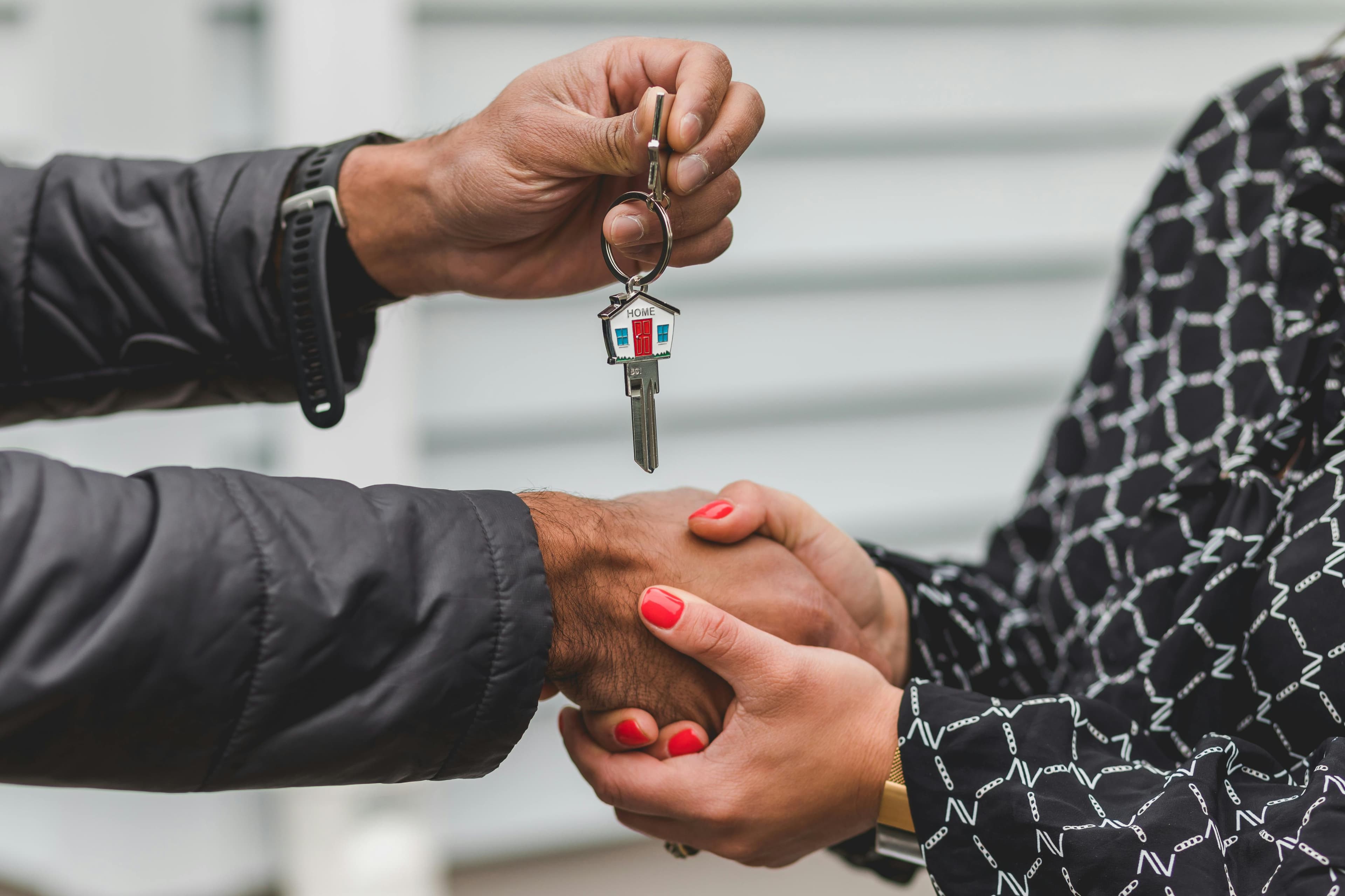 Hand holding house keys with keychain